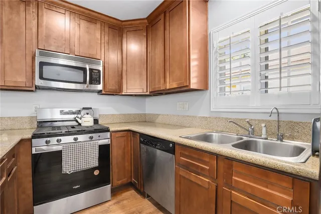 a kitchen with stainless steel appliances granite countertop a sink a stove and microwave