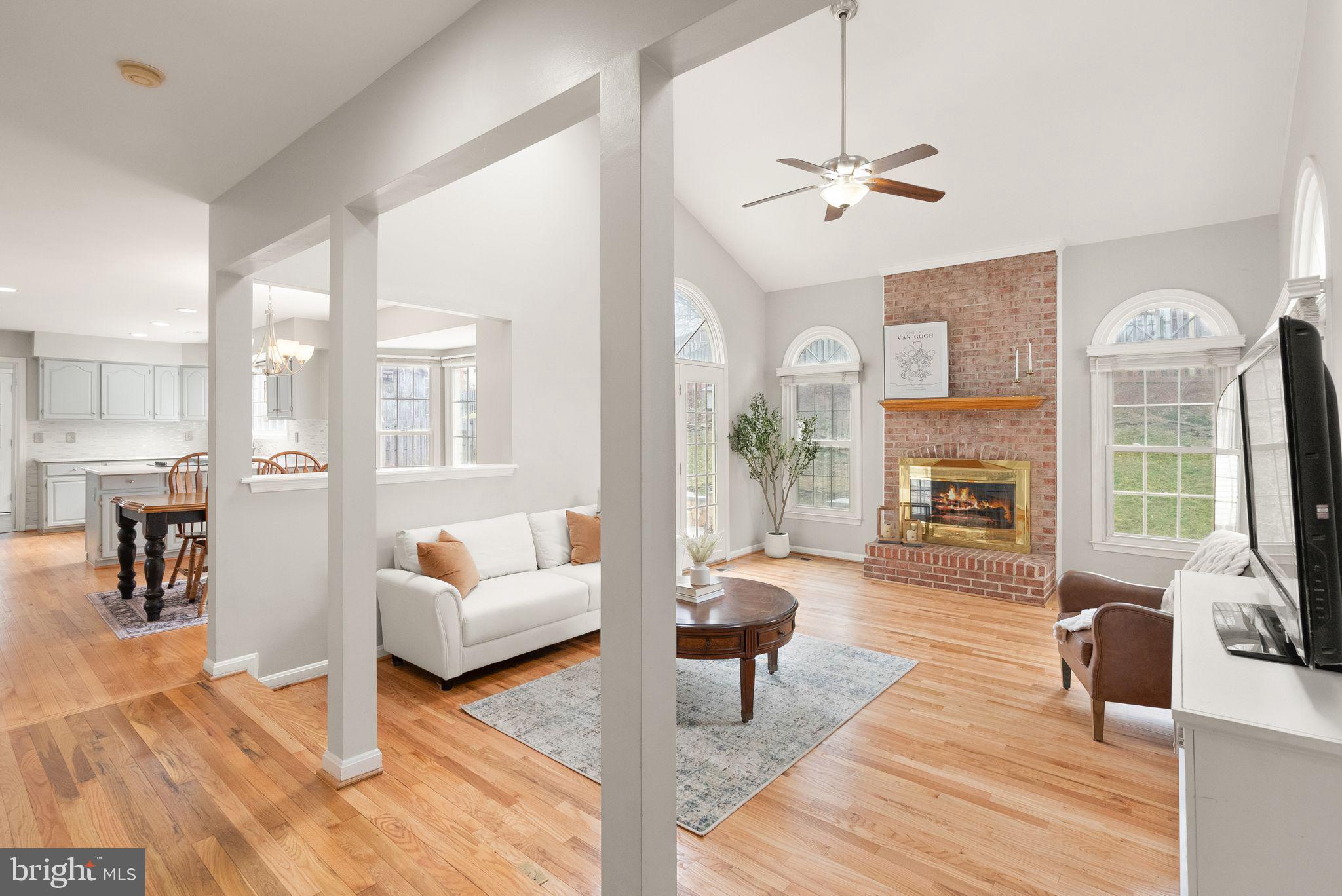 6833 Compton Heights Circle Clifton, VA 20124 - Photo 15 of 81 a living room with furniture a fireplace and a chandelier