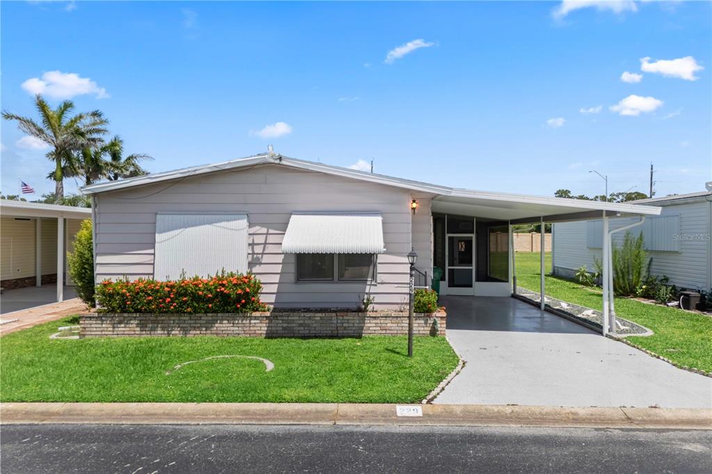 15550 Burnt Store Road, Unit 229 Punta Gorda, FL 33955 - Photo 22 of 40 a front view of a house with a garden and plants