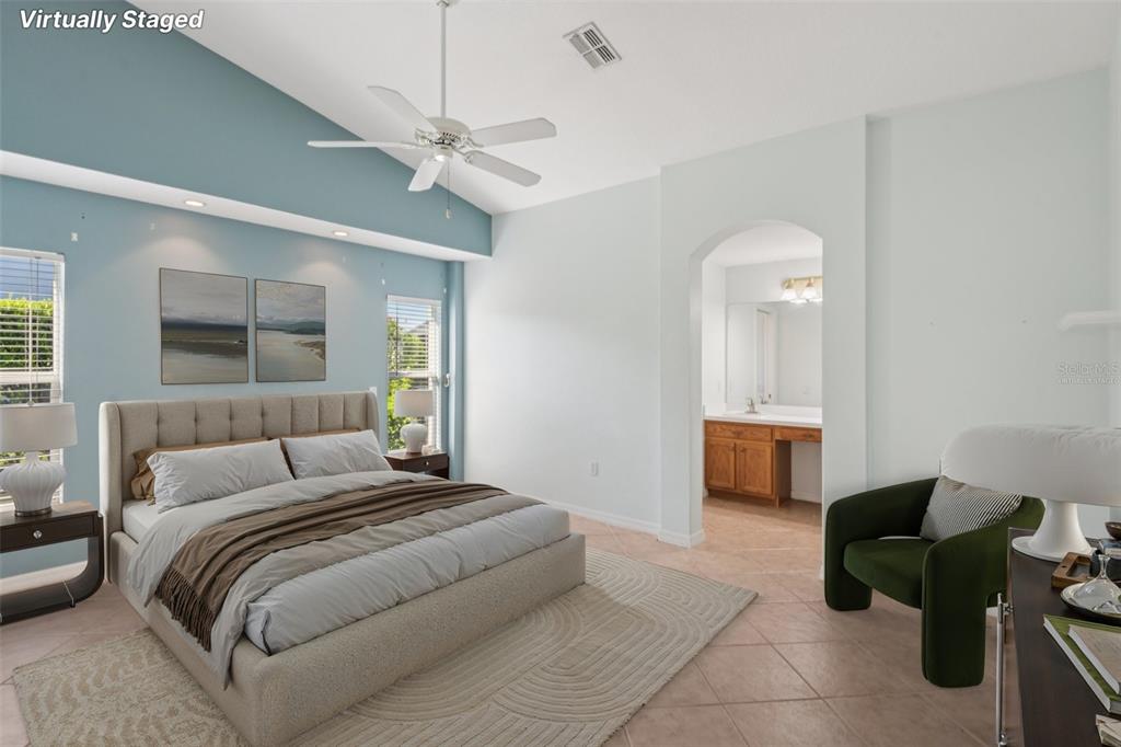 11705 Spindrift Loop Hudson, FL 34667 - Photo 11 of 34 a bedroom with a large bed and a chandelier