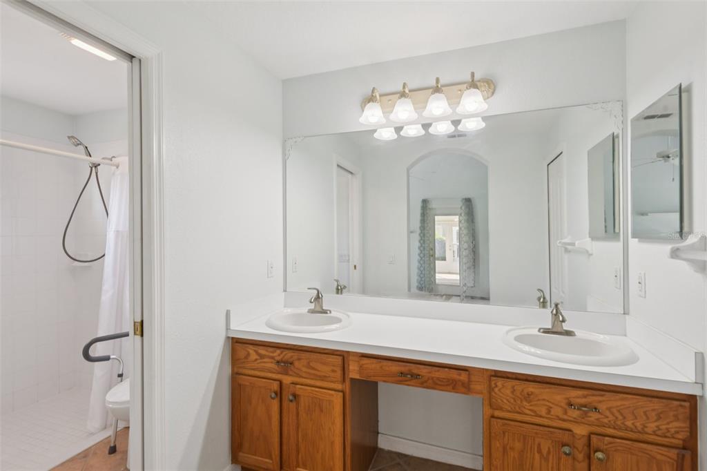 11705 Spindrift Loop Hudson, FL 34667 - Photo 13 of 34 a bathroom with a double vanity sink mirror and