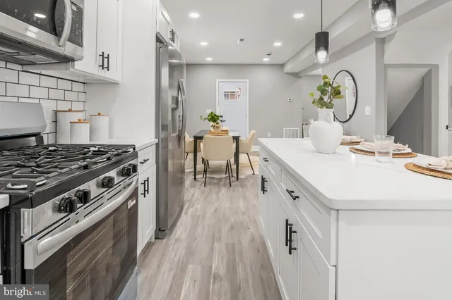 a kitchen with a sink stove and wooden floor