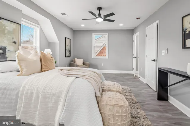 a bedroom with a bed painting on wall and a table