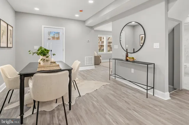 a living room with furniture a mirror and wooden floor
