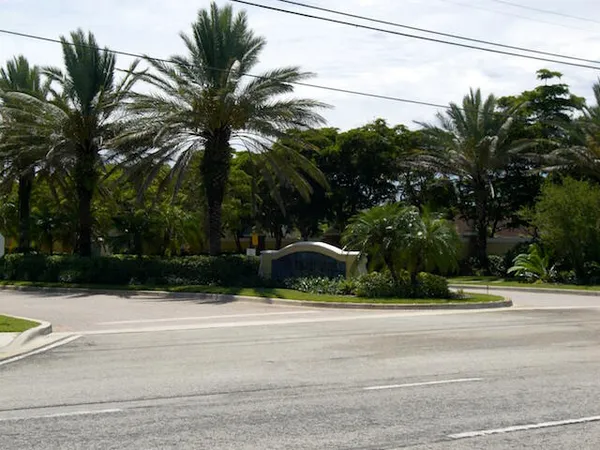 a view of a swimming pool with a yard and palm trees