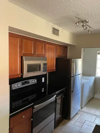 a kitchen with granite countertop a refrigerator stove and microwave