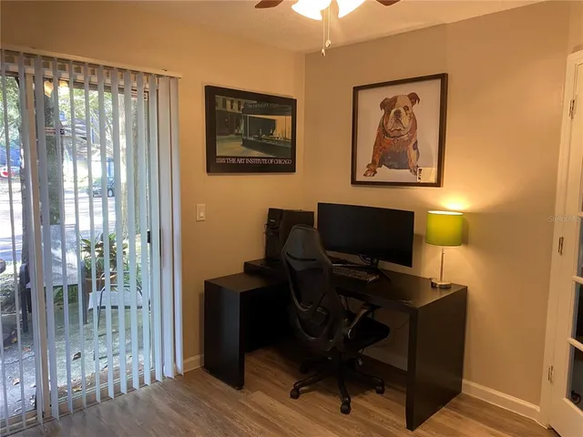a view of a workspace with furniture and a window