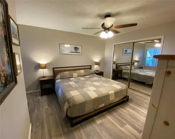 a bedroom with a bed and a large mirror with a wooden floor