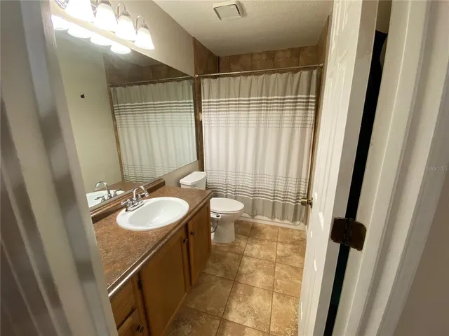 a bathroom with a double vanity sink toilet and a mirror