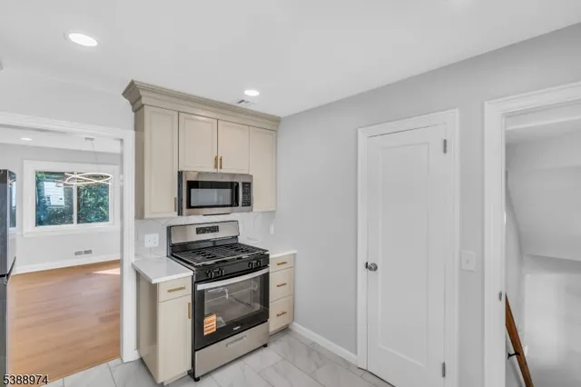 a kitchen with granite countertop a stove and a microwave