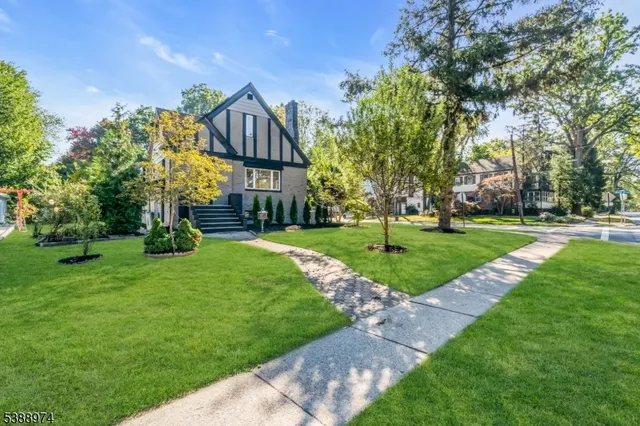 a view of a big house with a big yard and large trees