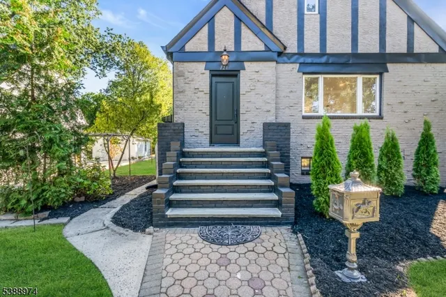 a front view of a house with a yard and trees