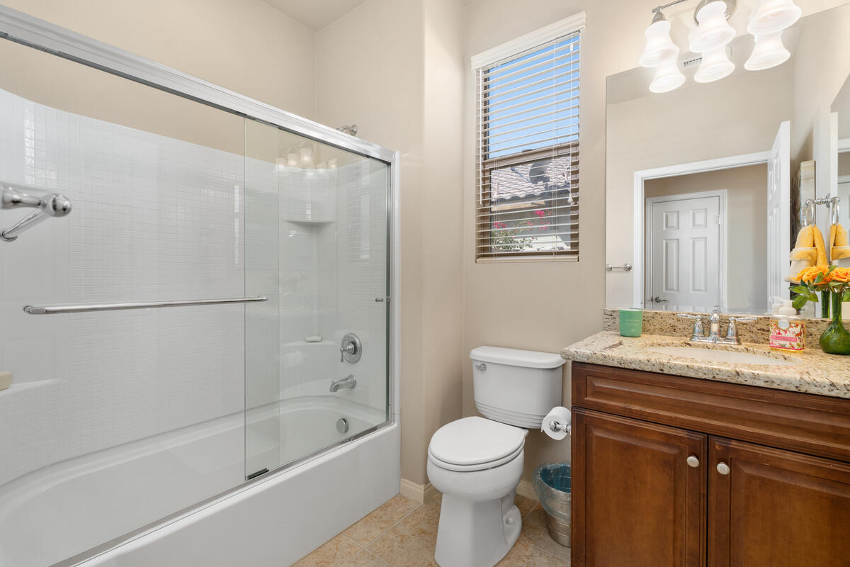 81220 Corte Tolon Indio, CA 92203 - Photo 18 of 42 a bathroom with a granite countertop sink a toilet and shower