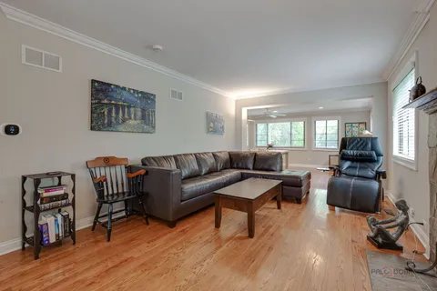a living room with furniture a bookshelf and a flat screen tv