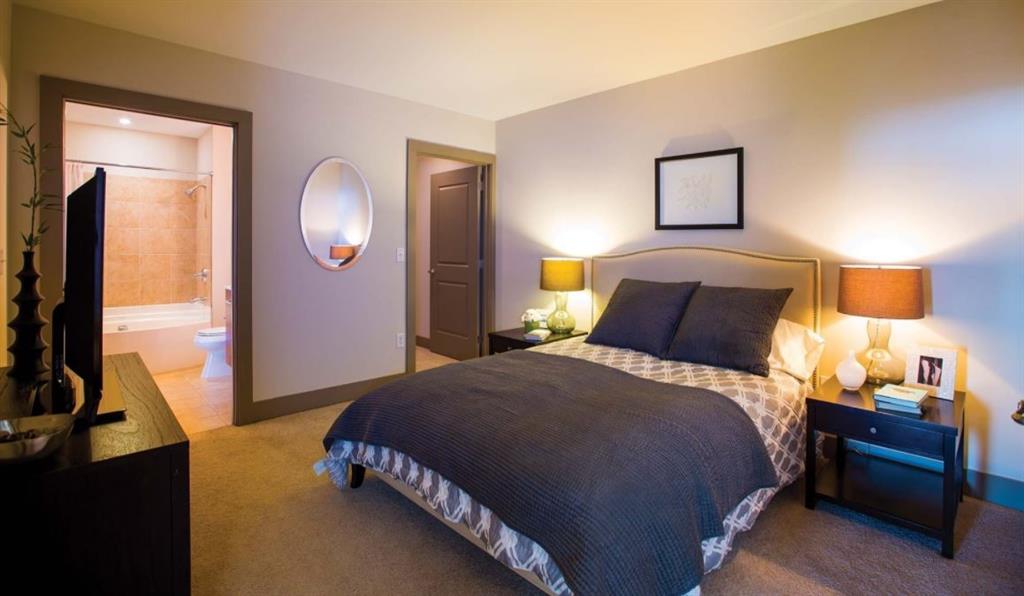 2171 Peachtree Road, Unit 1403 Atlanta, GA 30309 - Photo 7 of 25 a bedroom with a bed and wooden floor
