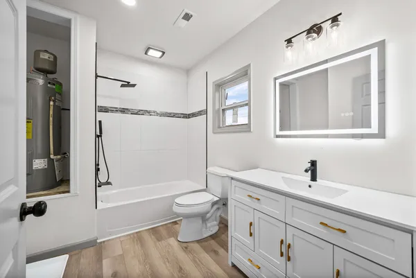 a bathroom with a toilet a sink and mirror