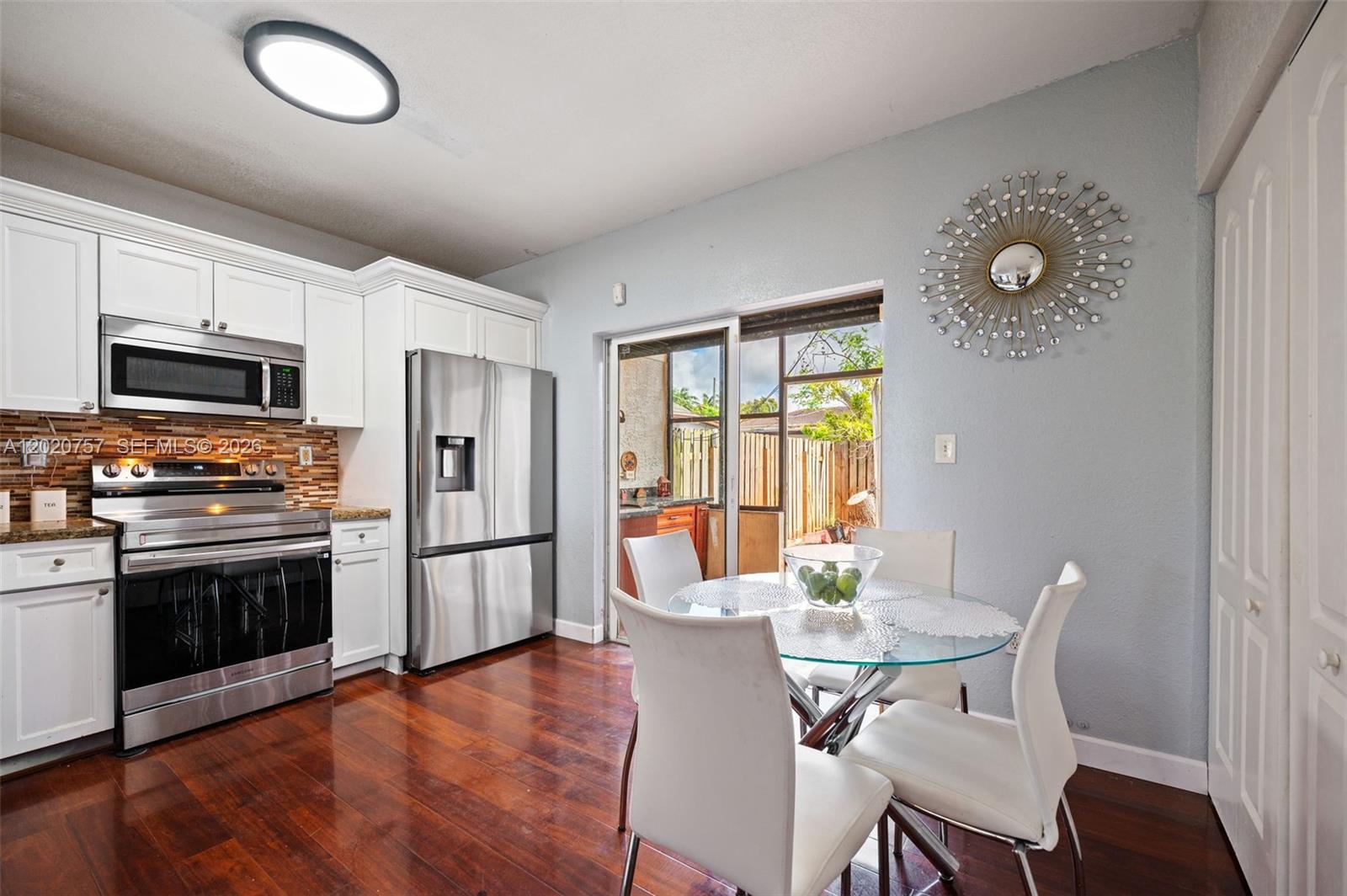 255 East 3rd Street, Unit 1 Hialeah, FL 33010 - Photo 4 of 38 a view of a dining room with furniture a kitchen and wooden floor