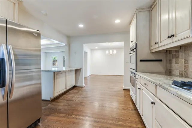 a kitchen with stainless steel appliances granite countertop a sink a stove a refrigerator and cabinets