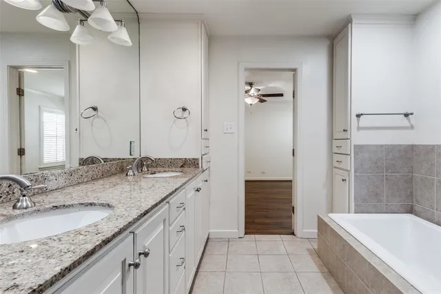 a spacious bathroom with a granite countertop sink mirror and bathtub