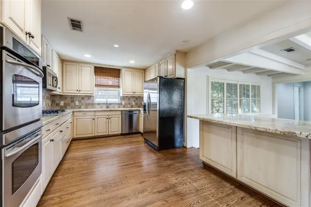 a view of a kitchen with a sink a kitchen counter space stainless steel appliances and a window