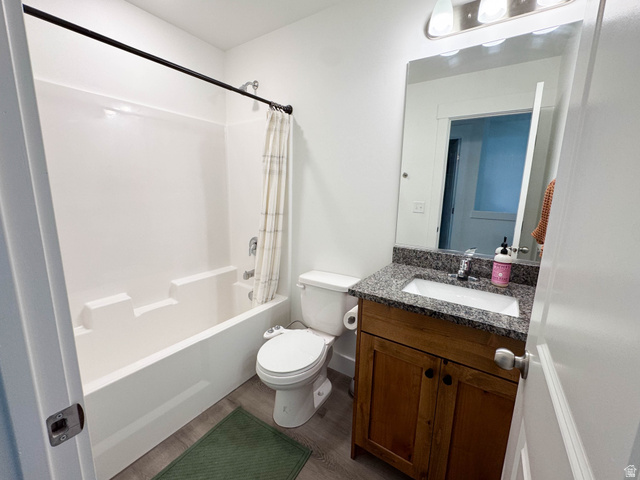 1486 West 2055th Street South Logan, UT 84339 - Photo 25 of 45 Bathroom featuring a white tub-shower combination, wood-finish vanity with cabinet storage, stone-finish countertop, and a chrome faucet