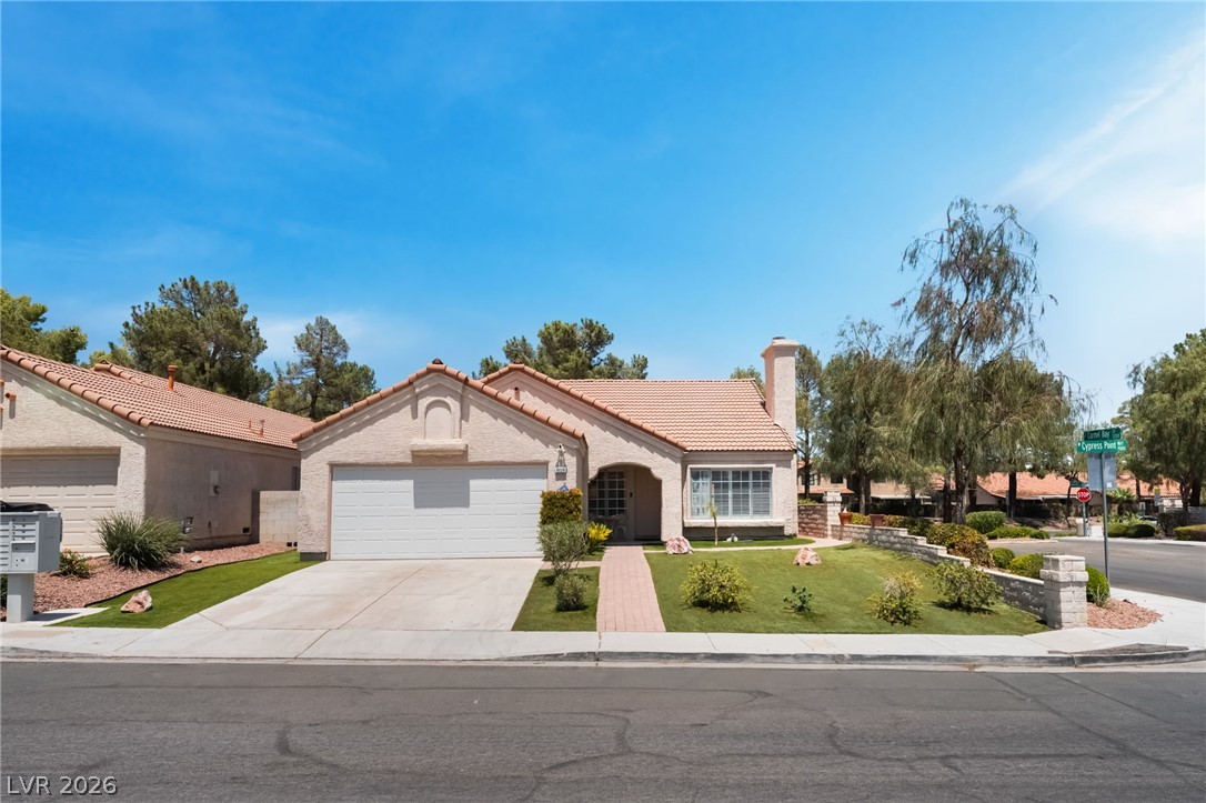 9028 Cypress Point Road Las Vegas, NV 89117 - Photo 36 of 39 A well-maintained stucco home with a terracotta tile roof and mature landscaping creates welcoming curb appeal.