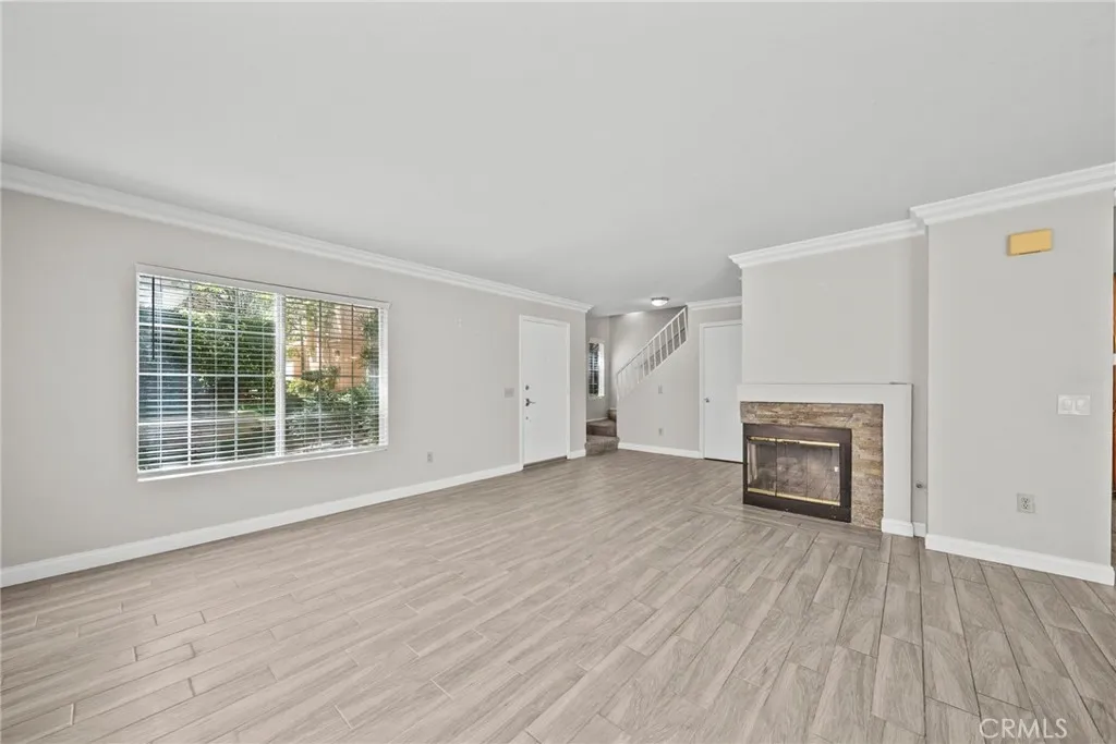 25118 Steinbeck Avenue Stevenson Ranch, CA 91381 - Photo 7 of 34 an empty room with a fireplace and windows