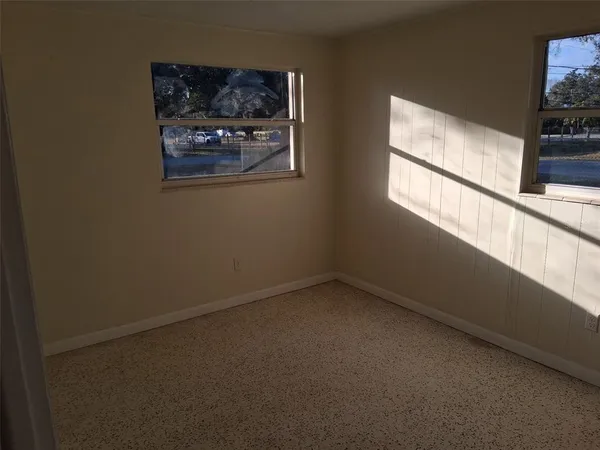 a view of a small space with wooden floor and a window