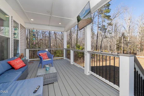 a balcony with wooden floor and furniture