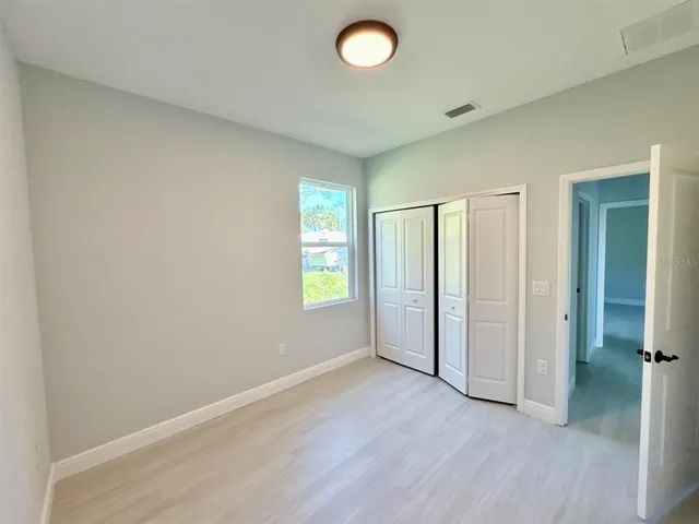 an empty room with windows and closet
