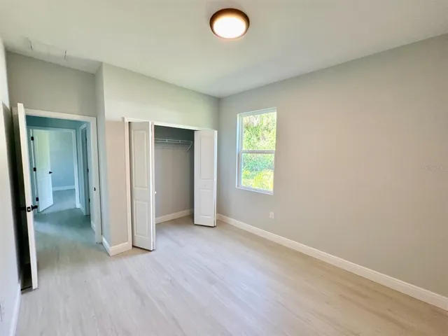 an empty room with closet and a window