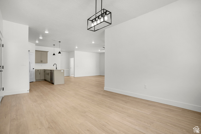 1631 West Century Lane, Unit C Mapleton, UT 84664 - Photo 10 of 31 Open-concept living area featuring light wood-finish flooring, recessed lighting, and a modern black metal chandelier