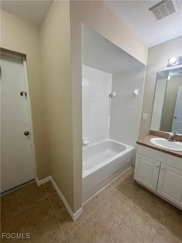 a bathroom with a tub sink and mirror