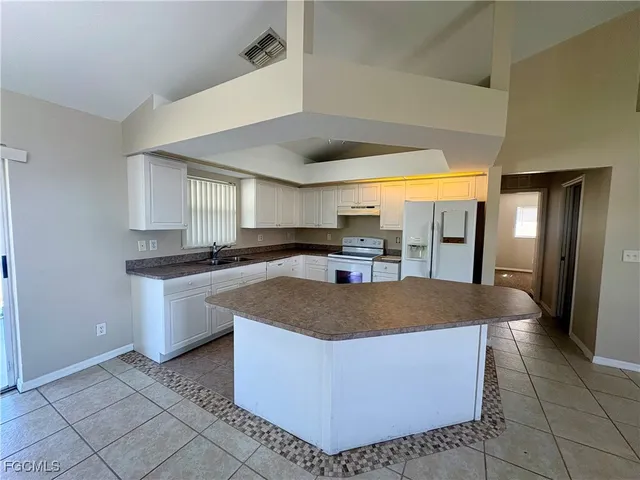 a kitchen with stainless steel appliances granite countertop a sink a stove and a refrigerator