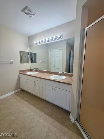 a bathroom with a double vanity sink and mirror