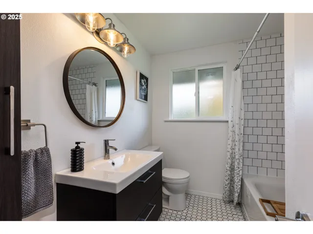 a bathroom with a toilet sink vanity and mirror