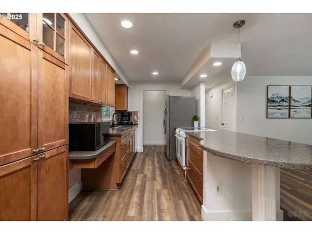 a kitchen with stainless steel appliances granite countertop a sink refrigerator and cabinets