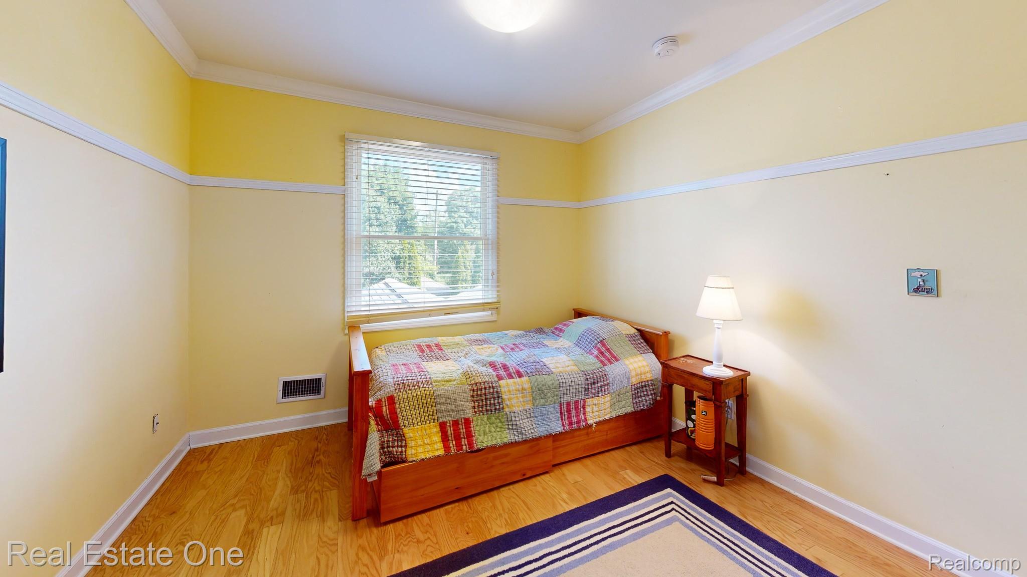 410 West 4th Street Rochester, MI 48307 - Photo 27 of 33 Room featuring wood-finish flooring, a double-hung window with blinds, baseboard trim, and crown molding