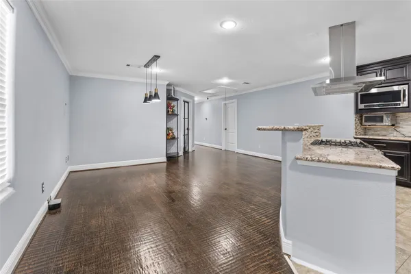 a view of a kitchen with a stove wooden floor and a window