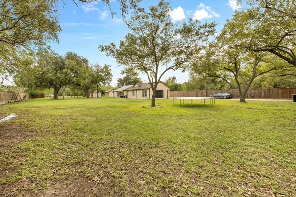 a view of a big yard with large trees