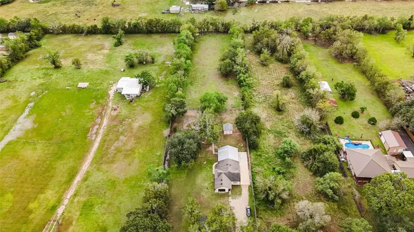 an aerial view of a residential houses with swimming pool and outdoor space
