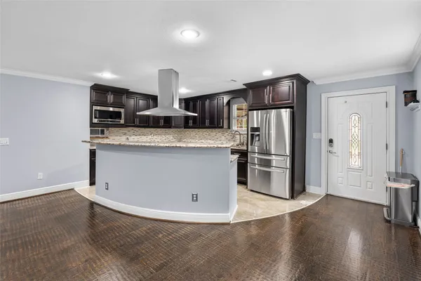 a kitchen with stainless steel appliances granite countertop a refrigerator and a stove