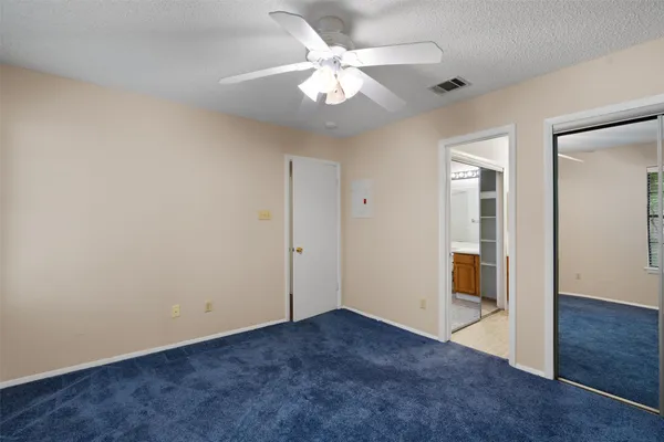 an empty room with fan and entrance