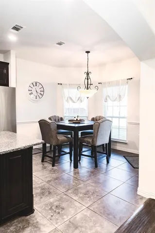 a kitchen with a kitchen island a sink dining table and chairs