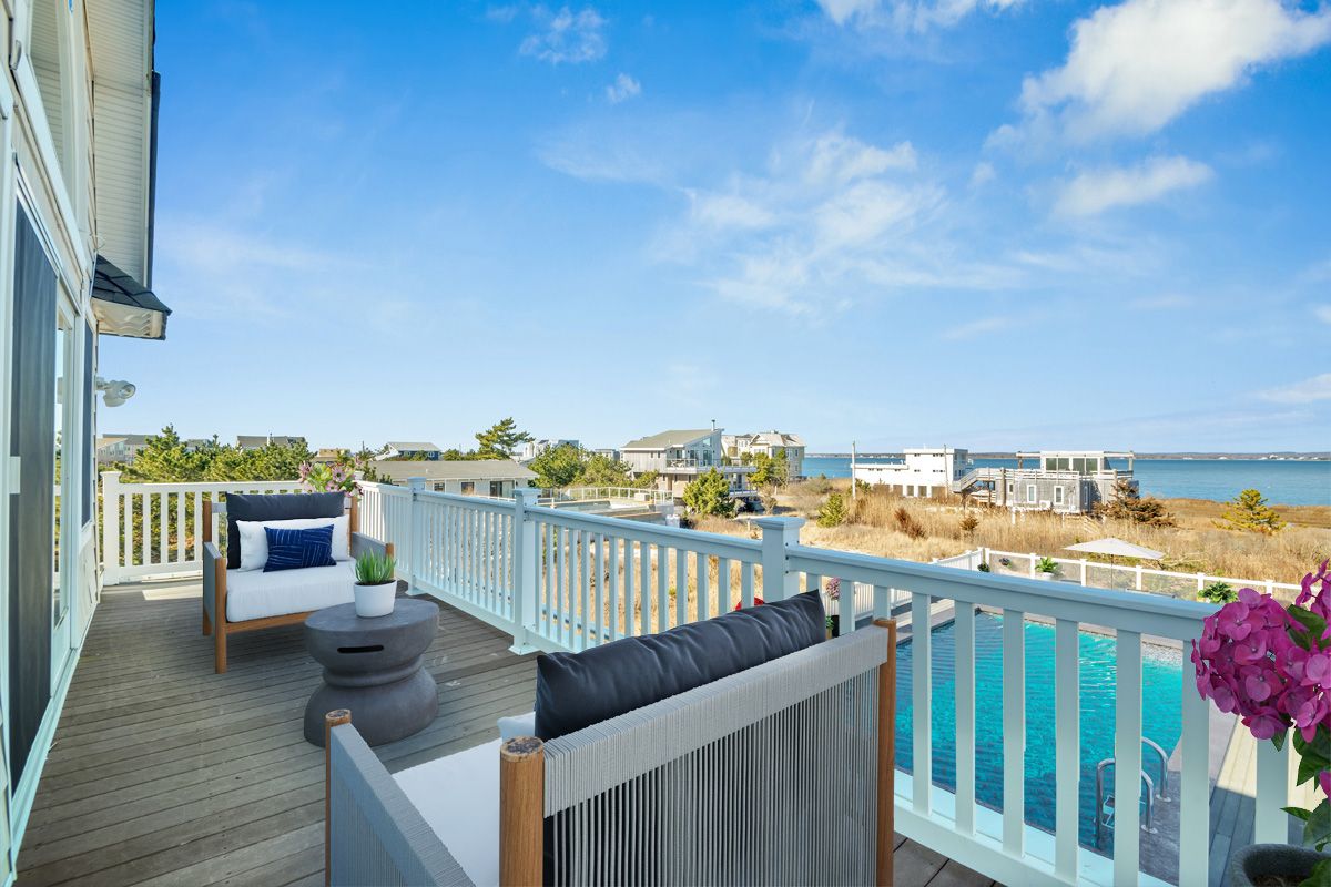 798 Dune Road Westhampton Beach, NY 11978 - Photo 14 of 22 a view of a balcony with wooden floor and iron stairs