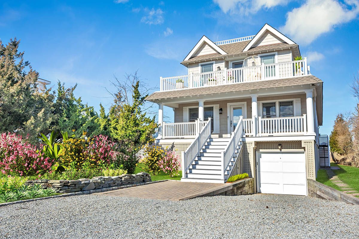 798 Dune Road Westhampton Beach, NY 11978 - Photo 2 of 22 a front view of a house with a yard and garage