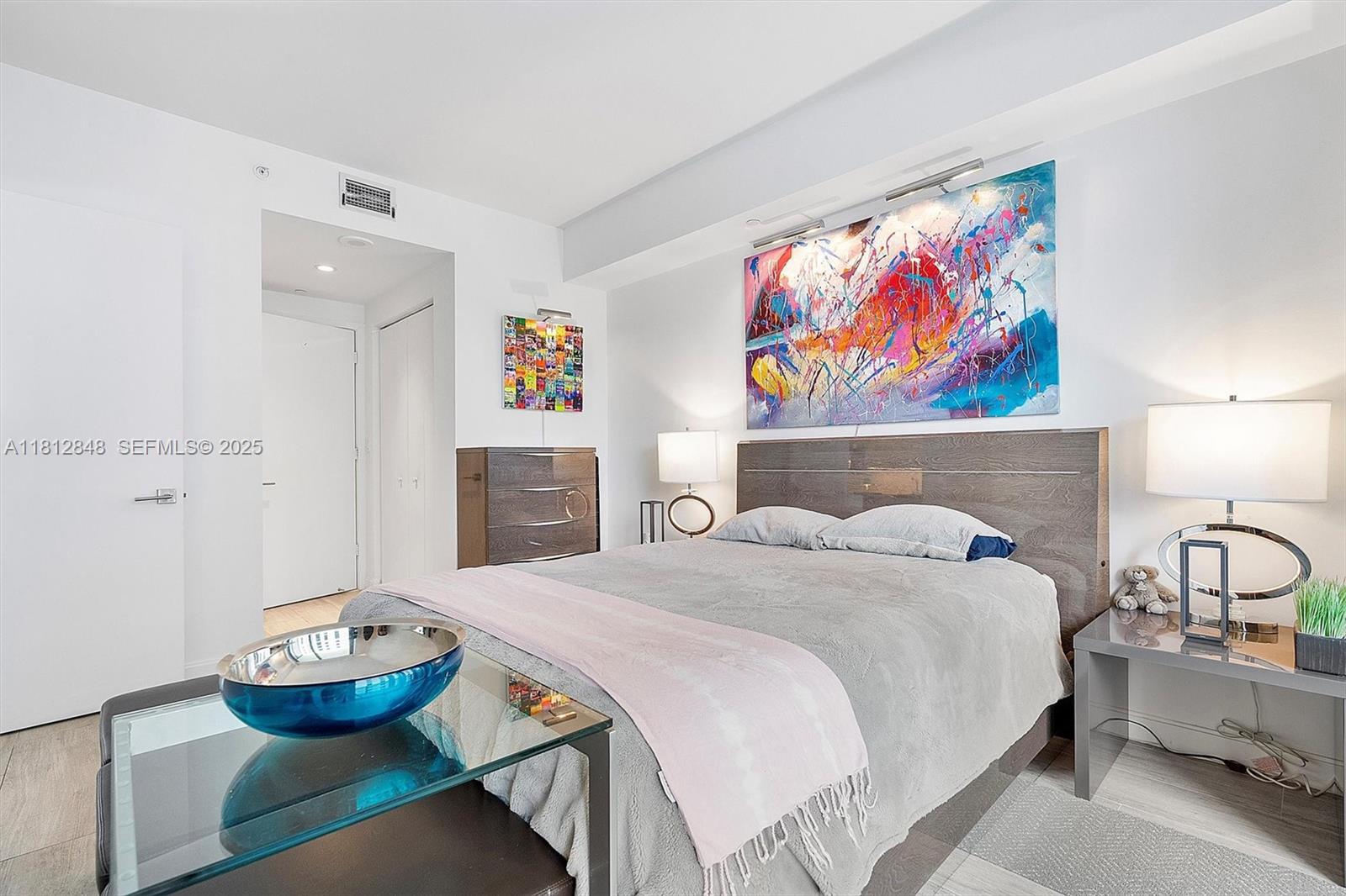 55 Southwest 9th Street, Unit 1510 Miami, FL 33130 - Photo 13 of 46 a bedroom with a bed and a painting on the wall