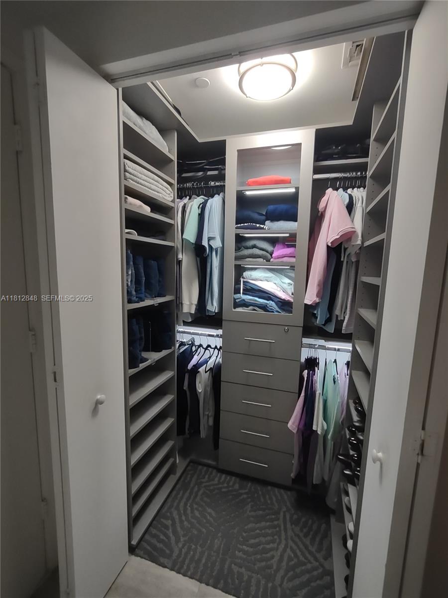 55 Southwest 9th Street, Unit 1510 Miami, FL 33130 - Photo 15 of 46 a view of walk in closet with clothes and shoes