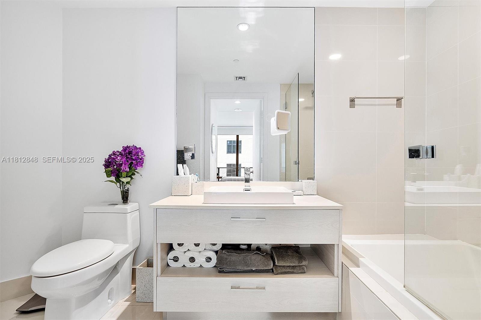 55 Southwest 9th Street, Unit 1510 Miami, FL 33130 - Photo 16 of 46 a bathroom with a sink toilet and a mirror