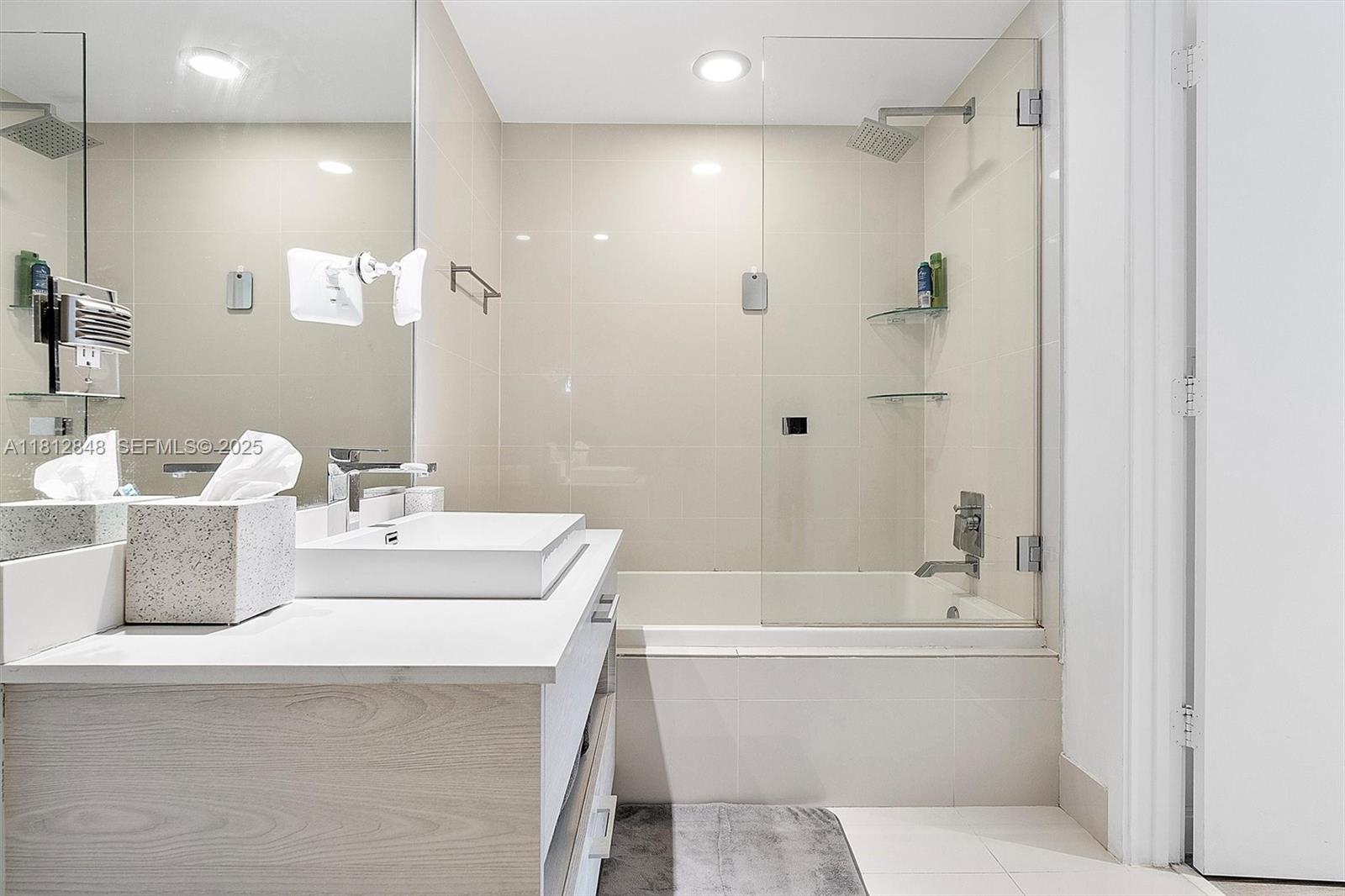 55 Southwest 9th Street, Unit 1510 Miami, FL 33130 - Photo 17 of 46 a bathroom with a bathtub a sink and a mirror